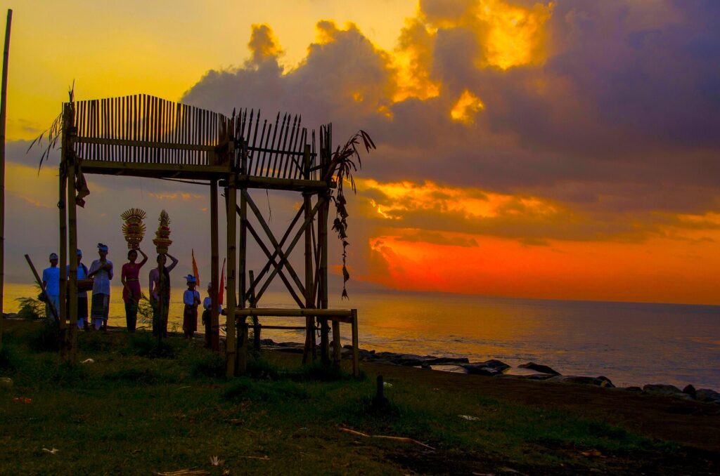 Upacara di tepi Pantai Keramas saat cahaya sore mengenai laut